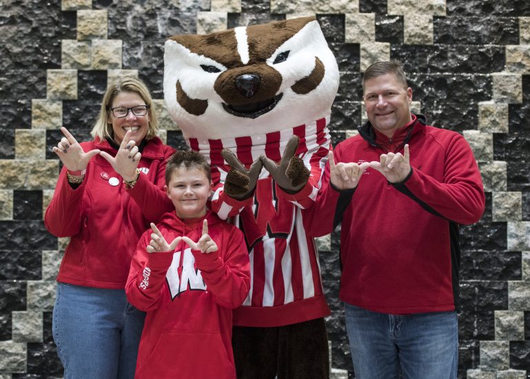 Business Badgers stand and smile with Bucky