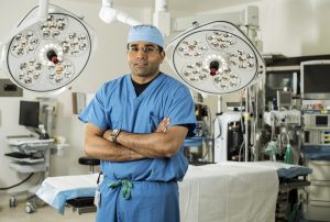 Surgeon wearing scrubs poses in a hospital