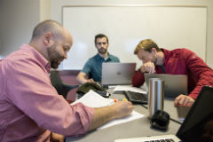 Christopher Roehrig, left, works alongside teammates Jacob Odell and Scott Maurer